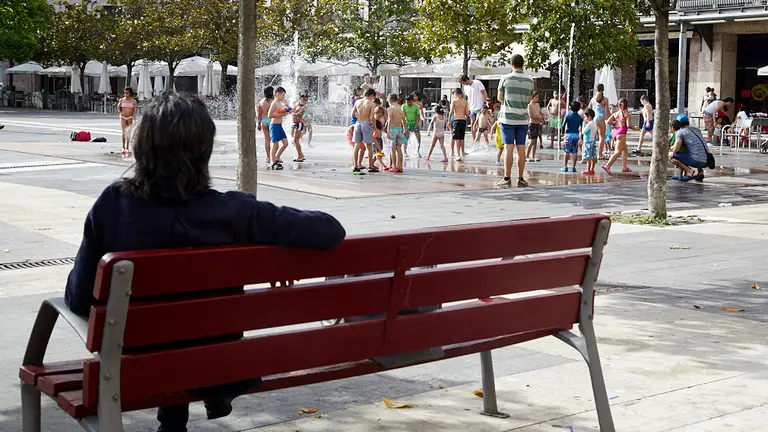 Unos niños juegan en la 'fuente de chorros' de la Plaza de Yamaguchi durante la primera ola de calor del verano en Pamplona. IÑIGO ALZUGARAY