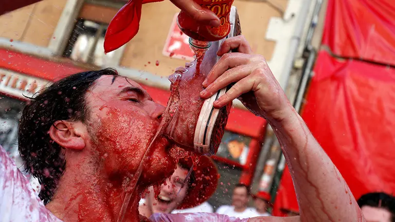 Varias personas viven los primeros momentos de San Fermín tras el Chupinazo. REUTERS