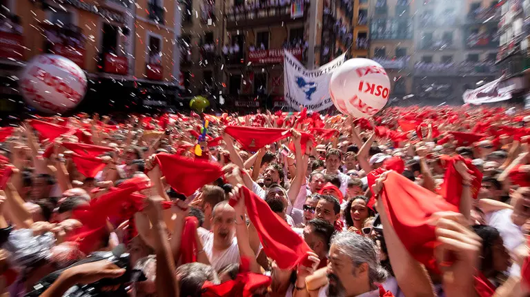 PAM04. Pamplona (Spain), 06/07/2019.- Thousands of revellers hold up their kerchiefs or 'panels' as they fireworks explode and confetti comes down in the Town Hall Square as the eight-day Fiesta de San Fermin kicks off in Pamplona, northern Spain, 06 July 2019. The famed fiesta is renowned for its morning running-with-the bulls each day for eight days and it non-stop partying atmosphere, al made internationally famous by American novelist Ernest Hemingway in his 1926 novel The Sun Also Rises. (Incendio, España, Estados Unidos) EFE/EPA/JIM HOLLANDER