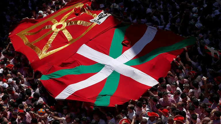 Una gran ikurriña ha colonizado la Plaza del Ayuntamiento durante el Chupinazo. AFP / REUTERS