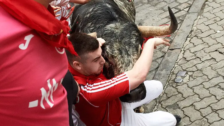 Un toro de la ganadería gaditana de Cebada Gago arrolla a un mozo a su paso por el tramo de Telefónica durante el segundo encierro de los Sanfermines 2019. EFE/Daniel Fernández