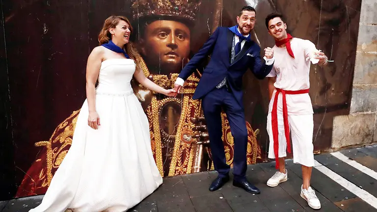Una pareja de recién casados se fotografía en la calle de La Estafeta de Pamplona momentos antes de que se celebre el tercer encierro de los Sanfermines 2019 que ha estado protagonizado por los toros de la ganadería abulense de José Escolar. EFE/ Jesus Diges.