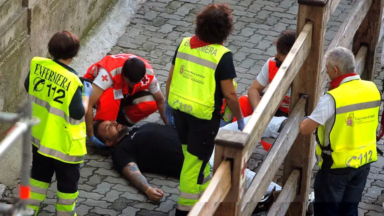 A reveller is helped by medical staff during the running of the bulls at the San Fermin festival in Pamplona, Spain, July 10, 2019. REUTERS/Jon Nazca *** Local Caption *** .