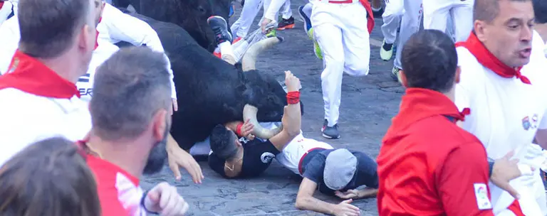 Cogida por asta de uno delos toros de Victoriano del Río en el tramo de Telefónica durante el quinto encierro de San Fermín 2019. IOSU PEZONAGA.