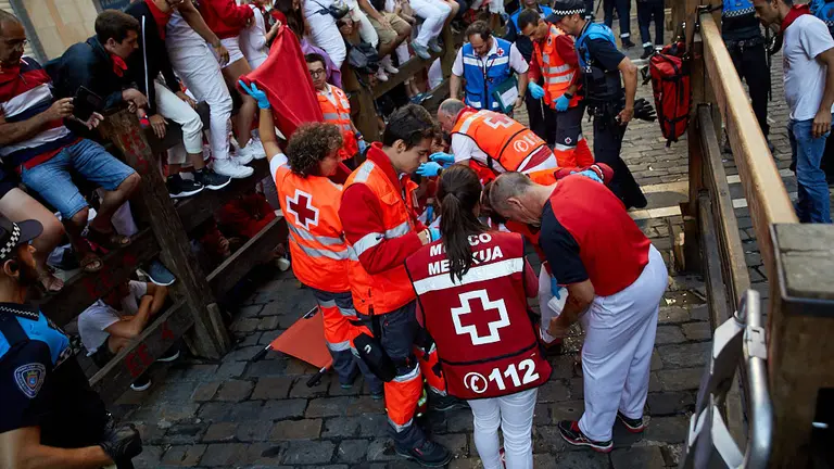 Los servicios sanitarios atienden a los heridos leves del quinto encierro de los Sanfermines 2019 en el tramo de Mercaderes. IÑIGO ALZUGARAY