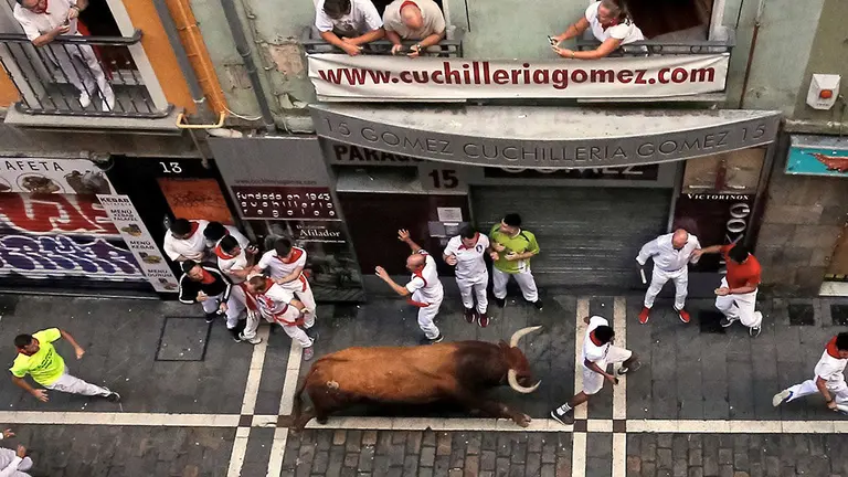 Los toros de la ganadería sevillana de Miura, a su paso por el inicio del tramo de la Estafeta, durante el último encierro de los Sanfermines 2019. EFE/J.P. Urdiroz