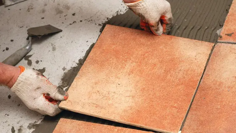 Imagen de un albañil colocando baldosas en las obras de reforma de una casa ARCHIVO