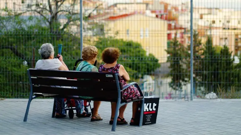 Varias personas mayores sentadas en un banco ARCHIVO