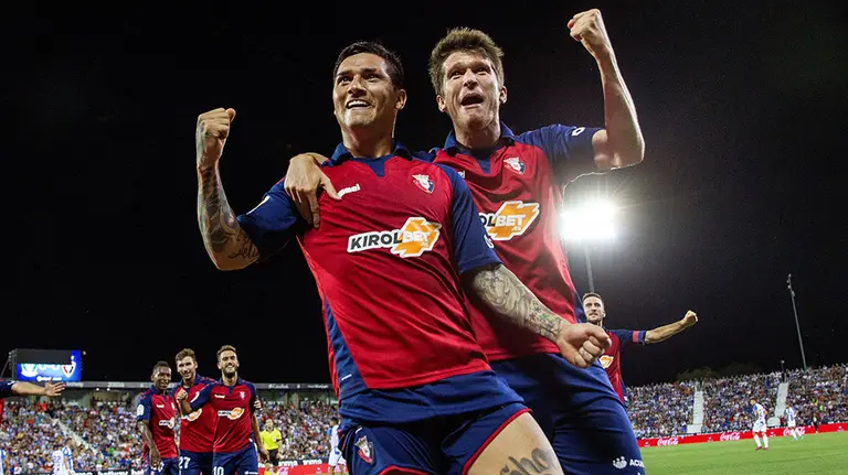 El delantero argentino del Club Atlético Osasuna Ezequiel Chimy Ávila (i) celebra junto a Marc Cardona su gol, primero del equipo ante el Leganés, durante el partido correspondiente a la primera jornada de LaLiga Santander que se disputa hoy sábado en el Estadio Municipal de Butarque, en Leganés. EFE/Rodrigo Jiménez