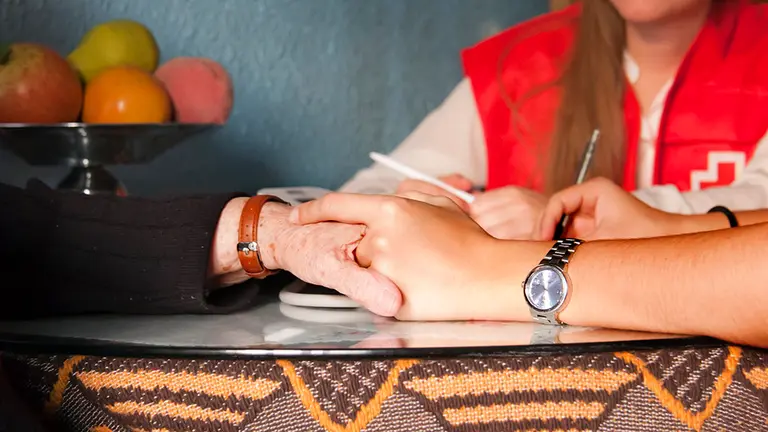 Imagen de una voluntaria visitando un domicilio de una persona mayor. CEDIDA