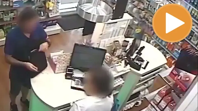 Imagen del &#39;ladrón de farmacias&#39; actuando en una de ellas y amenazando a la empleada con un cuchillo. TWITTER