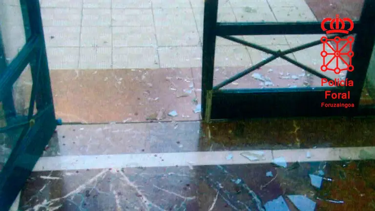 Imágenes del cristal de la puerta del portal roto tras el forcejeo. POLICÍA FORAL