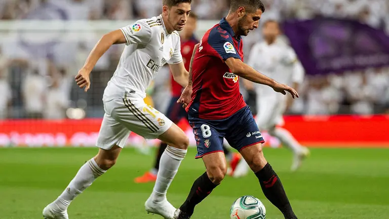 GRAF8788. MADRID, 25/09/2019.- El centrocampista uruguayo del Real Madrid Federico Valverde (i) disputa un balón con Fran Mérida, centrocampista español del Osasuna, durante el partido entre ambos equipos correspondiente a la sexta jornada de LaLiga Santander que se disputa este miércoles en el estadio Santiago Bernabéu de Madrid. EFE/ Rodrigo Jiménez