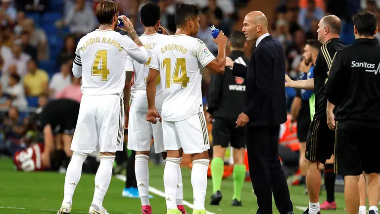 GRAF8862. MADRID, 25/09/2019.- El técnico francés del Real Madrid Zinedine Zidane (d), conversa con sus jugadores Casemiro y Sergio Ramos durante el partido correspondiente a la sexta jornada de Liga en Primera División que se disputa este miércoles en el estadio Santiago Bernabéu, en Madrid. EFE/ Juanjo Martín