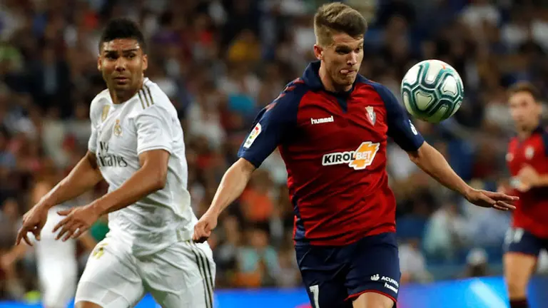 El centrocampista brasileño del Real Madrid Carlos Casemiro (i) pelea un balón con el delantero del Osasuna Marc Cardona durante el partido de LaLiga que se disputa esta noche en el Estadio Santiago Bernabéu en Madrid. EFE/ Rodrigo Jiménez