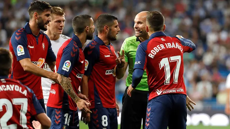 Los jugadores de Osasuna protestan una jugada al colegiado Mateu Lahoz durante el encuentro correspondiente a la sexta jornada de primera división que disputan esta noche frente al Real Madrid en el estadio Santiago Bernabéu, en Madrid. EFE/JuanJo Martín.