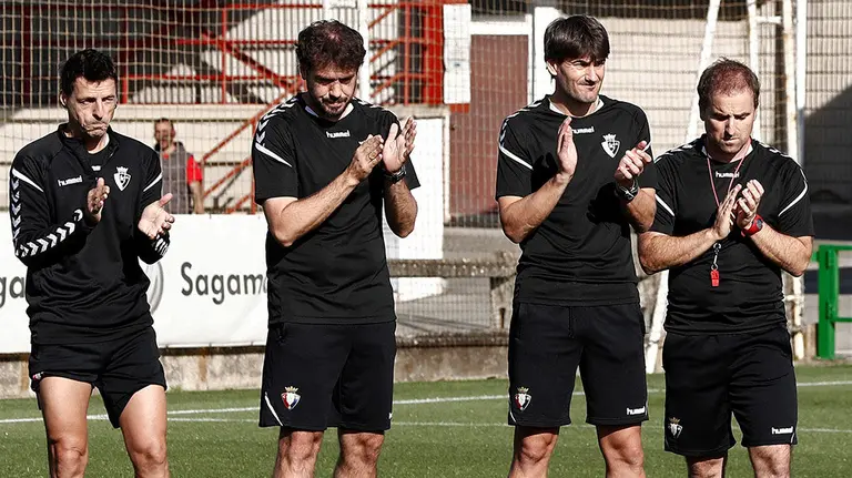 El entrenador del Club Atlético Osasuna, Jagoba Arrasate (d), junto a su cuerpo técnico y el resto de la plantilla del equipo rojillo, guardan un minuto de silencio antes de comenzar el entrenamiento de este viernes en memoria del responsable de Deportes de la Agencia EFE en Navarra Fermín Zariquiegui que falleció ayer jueves en Pamplona a los 51 años. EFE/ Jesús Diges