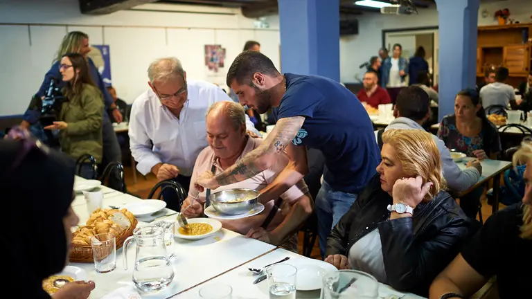Jugadores del Club Atlético Osasuna acuden al comedor solidario Paris 365 como voluntarios para servir comida a sus usuarios, con motivo del décimo aniversario de su apertura. MIGUEL OSÉS