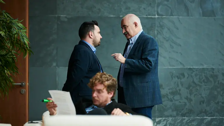 El parlametario Carlos Mena (i) habla con el consejero Aierdi mientras Maiorga Ramírez (EH Bildu) consulta unos papeles. PABLO LASAOSA