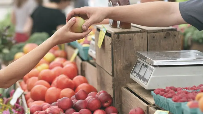 Una persona comprando fruta en el mercado ARCHIVO