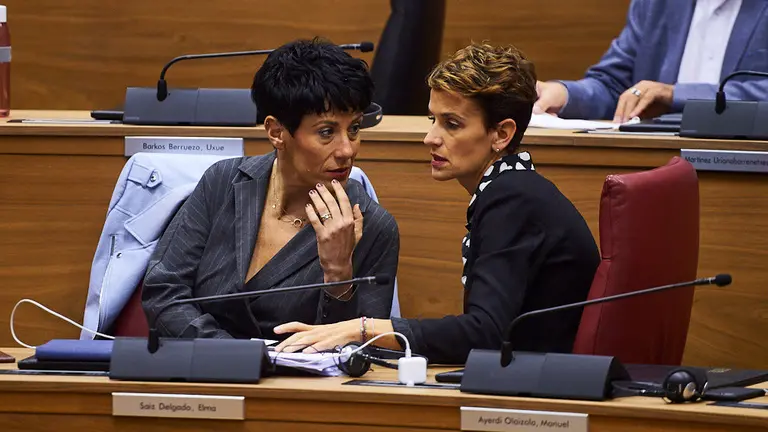 Elma Saiz, consejera de hacienda del gobierno de Navarra, habla con la presidenta de Navarra María Chivite durante el pleno parlamentario. MIGUEL OSÉS