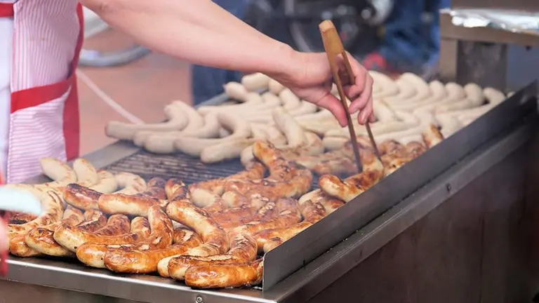 Una persona cocinando salchichas ARCHIVO