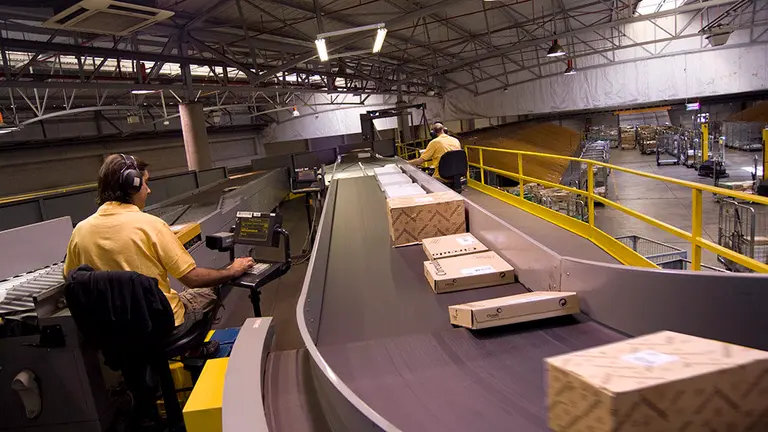 Un operario trabaja en un centro de operaciones de paquetería. CORREOS