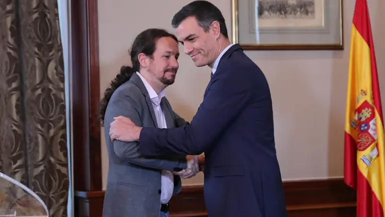 El presidente del Gobierno en funciones, Pedro Sánchez y el líder de Podemos, Pablo Iglesias, se abrazan en el Congreso de los Diputados después de firmar el principio de acuerdo para compartir un gobierno de coalición tras las elecciones generales del pasado domingo, en Madrid (España), a 12 de noviembre de 2019. EUROPA PRESS