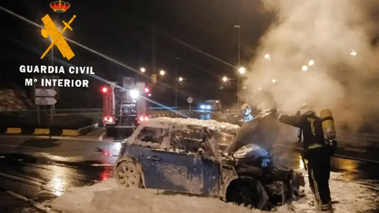 Los bomberos trabajan en la extinción de un incendio de un vehículo en la ronda de Pamplona. GUARDIA CIVIL