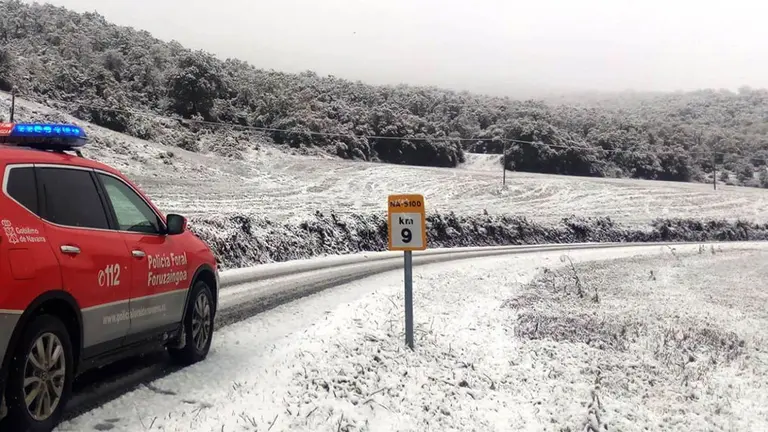 Un vehículo de la Policía Foral circula por una carretera de Navarra casi cubierta por la nieve POLICÍA FORAL