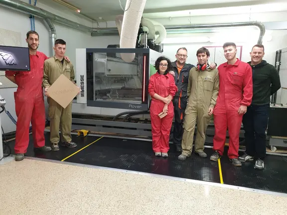El director del CI San Juan-Donibane, Alfonso Roncal, junto al profesor Alfonso Erro y alumnas y alumnos del centro, ante la máquina de control numérico ROVER A SMART. CEDIDA.