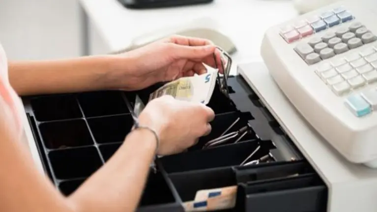 Una persona manipula una caja registradora ARCHIVO