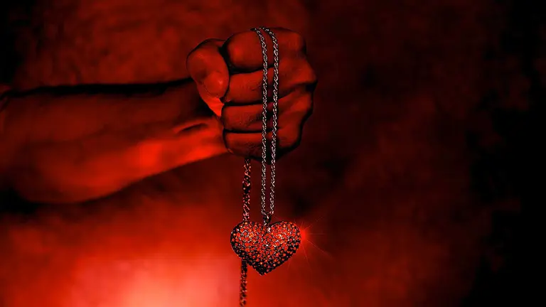 Una persona sujeta fuertemente una joya en forma de corazón