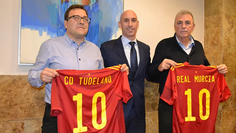 Los presidentes del Tudelano, Jesús Miranda, y del Real Murcia, Francisco Tornel, sostienen las camisetas junto al Presidente de la RFEF Luis Rubiales. RFEF.
