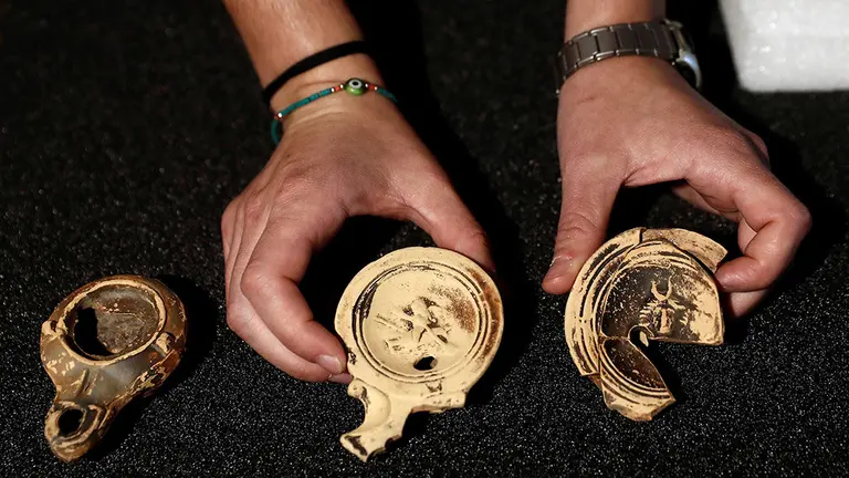 a arque&oacute;loga Ohiane Mendizabal, muestra varias lucernas, unas l&aacute;mparas de aceite empleadas com&uacute;nmente para iluminar las estancias que forman parte de los hallazgos realizados en el yacimiento de Zaldua, en Auritz&ndash;Burguete, que dan muestra de la importante romanizaci&oacute;n existente en las inmediaciones de la calzada del Pirineo que un&iacute;a Astorga con Burdeos. Los objetos encontrados datan de &eacute;pocas comprendidas entre los siglos I y IV, destaca un anillo de oro con un entalle de nicolo onyx azul con una talla que, se sospecha que representa a la diosa fortuna sosteniendo una cornucopia. Tambi&eacute;n figuran objetos de la vida cotidiana como un dado de bronce, fichas de juego as&iacute; como objetos de adorno personal como alfileres para sujetar el pelo. EFE/ Jes&uacute;s Diges