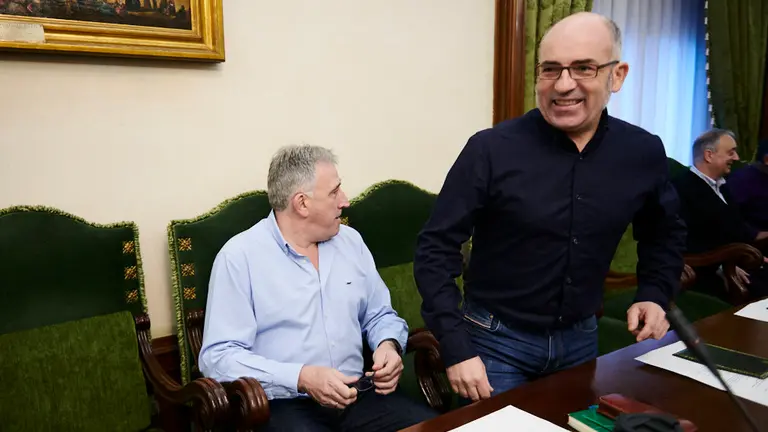 El concejal de EH Bildu en el Ayuntamiento de Pamplona, Joxe Abaurrea (d) pasa por delante de Joseba Asirón para acceder a su asiento en el pleno extraordinatio del Ayuntamiento de Pamplona para aprobar los presupuestos. PABLO LAASAOSA