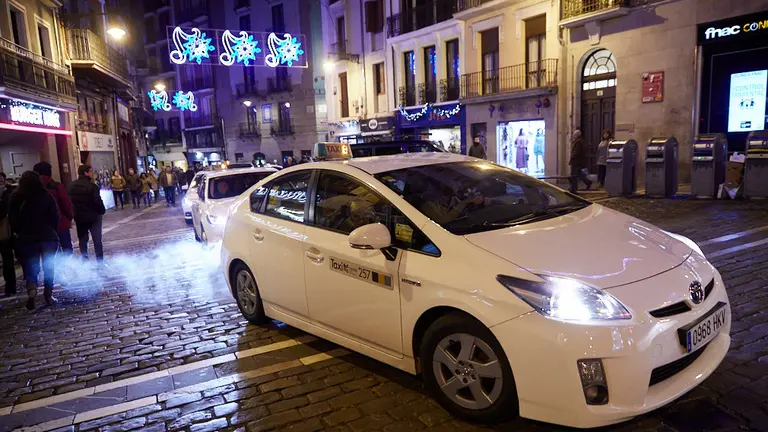 El alcalde, Enrique Maya, recibe a personas de residencias de la tercera edad que recorren en taxi la ciudad para ver las luces y el ambiente navideño de Pamplona. IÑIGO ALZUGARAY