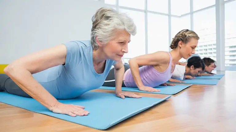 Varias personas practicando yoga durante una clase. ARCHIVO