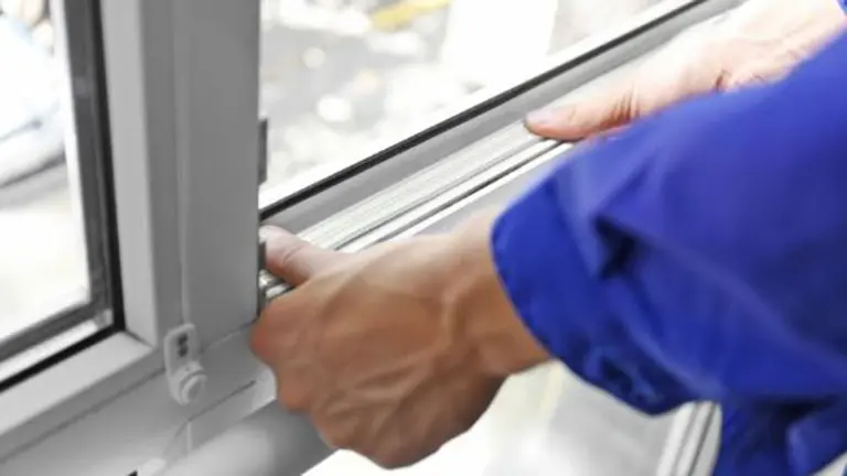 Un operario arreglando una ventana. ARCHIVO