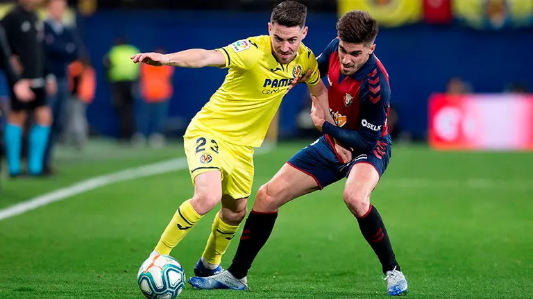 El defensa del Villarreal Moi Gómez (i) trata de escapar de Rubén García, de Osasuna, durante el partido de Liga en Primera División que disputan este domingo en el estadio de La Cerámica, en Villarreal. EFE/Domenech Castelló