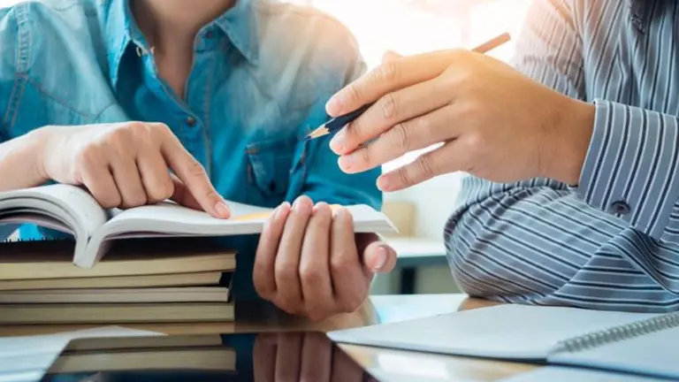 Dos personas dando una clase de idiomas. ARCHIVO