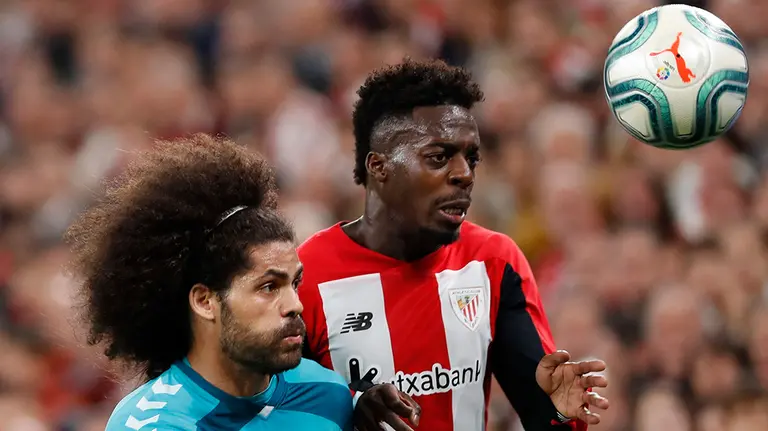 GRAF1399. BILBAO, 16/02/2020.- El delantero Iñaki Williams (d) del Athletic de Bilbao y el defensor Aridane Hernández (i) de Osasuna, disputan el balón durante el partido correspondiente a la vigésimo cuarta jornada de LaLiga Santander, que se celebra este domingo en estadio de San Mamés. EFE/Luis Tejido
