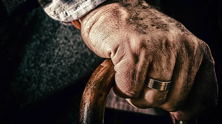 Un hombre anciano se sujeta en su bastón. ARCHIVO