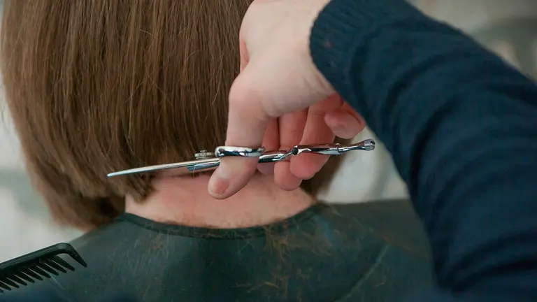Un peluquero corta el pelo a una clienta. ARCHIVO