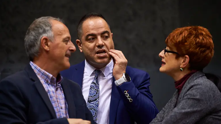 Ramón Alzorriz, portavoz del PSN, habla con Bakartxo Ruiz y Adolfo Araiz, miembros de Eh Bildu, durante el pleno parlamentario. MIGUEL OSÉS