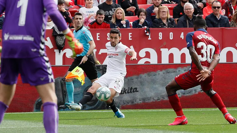 El centrocampista del Sevilla FC, Jesús Navas (c), centra el balón ante el defensa ecuatoriano del Osasuna, Pervis Estupiñán (d), durante el partido de Liga de Primera División disputado hoy en el estadio Sanchez Pizjuan. EFE/Jose Manuel Vidal.