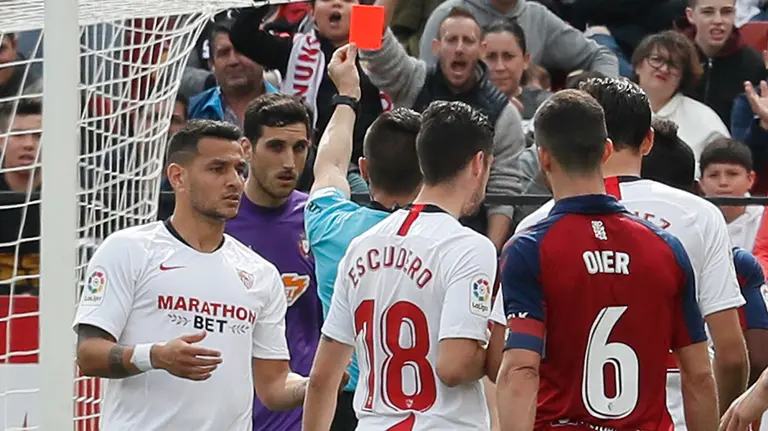 El árbitro Del Cerro Grande (3i) expulsa con tarjeta roja al portero de Osasuna Sergio Herrera (2i) durante el partido de Liga de Primera disputado este domingo en el estadio Sánchez Pizjuán. EFE/Jose Manuel Vidal