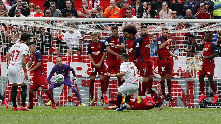 El delantero portugués del Sevilla Marcos Paulo Mesquita &#34;Rony&#34; Lópes (de espaldas) dispara una faltadurante el partido de Liga de Primera División disputado este domingo ante el Osasuna en el estadio Sánchez Pizjuán. EFE/José Manuel Vidal