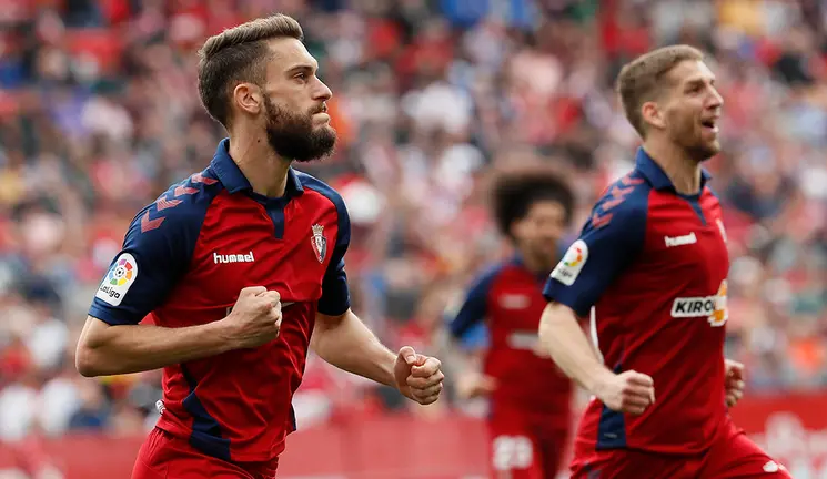 El centrocampista del Osasuna Roberto Torres (i) celebra con sus compañeros el gol marcado de penalty al Sevilla, segundo para el equipo navarro, durante el partido de Liga de Primera División disputado este domingo en el estadio Sánchez Pizjuán. EFE/José Manuel Vidal