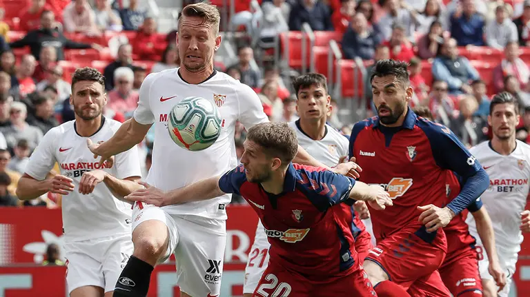 El centrocampista holandés del Sevilla Luuk de Jong (i) y el centrocampista serbio del Osasuna Darko Brasanac (c) durante el partido de Liga de Primera División disputado este domingo en el estadio Sánchez Pizjuán. EFE/José Manuel Vidal